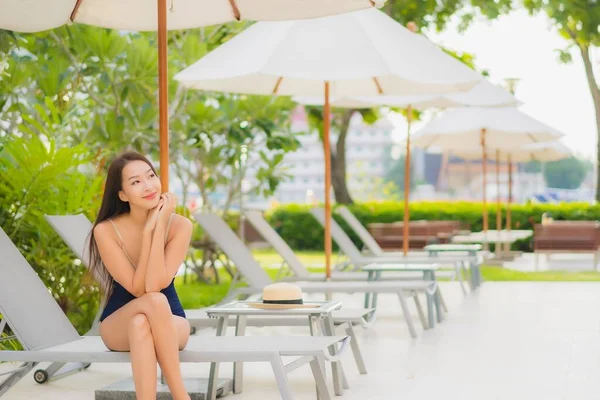 在度假胜地的室外游泳池边 年轻美丽的亚洲女人在度假旅行时 放松地笑着 — 图库照片