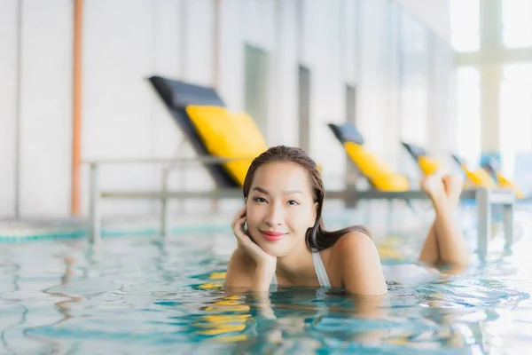 美しい若いアジアの女性の肖像旅行休暇にホテルのリゾートでスイミングプールの周りの笑顔をリラックス — ストック写真