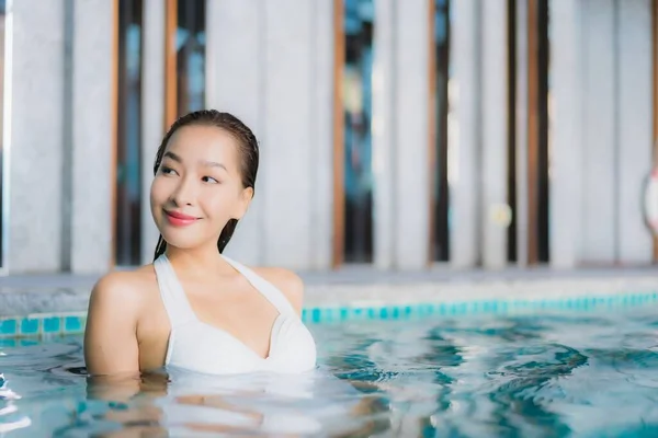 美しい若いアジアの女性の肖像旅行休暇にホテルのリゾートでスイミングプールの周りの笑顔をリラックス — ストック写真