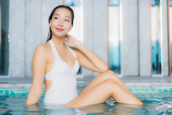 Portrait beautiful young asian woman relax smile around swimming pool in hotel resort on traval vacation