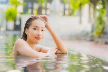 Güzel bir Asyalı kadın portresi. Rahatlayın. Yüzme havuzu etrafında gülümseyin.