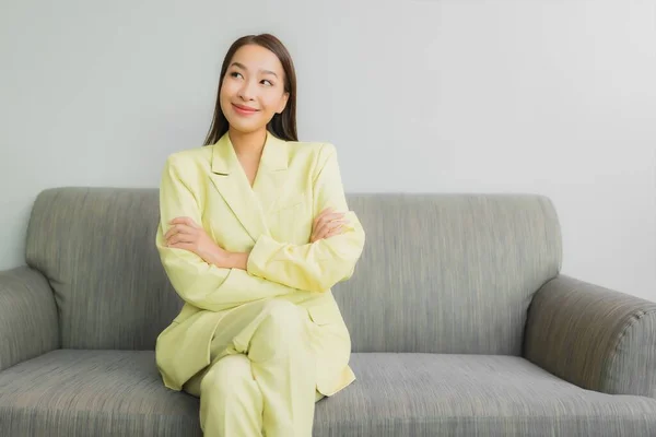肖像美しい若いアジアの女性は リビングルームのインテリアでソファに笑顔で座って — ストック写真