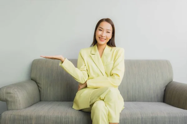 肖像美しい若いアジアの女性は リビングルームのインテリアでソファに笑顔で座って — ストック写真
