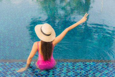 Güzel bir Asyalı kadın portresi. Tatil tatilinde açık havada yüzme havuzunun keyfini çıkar.
