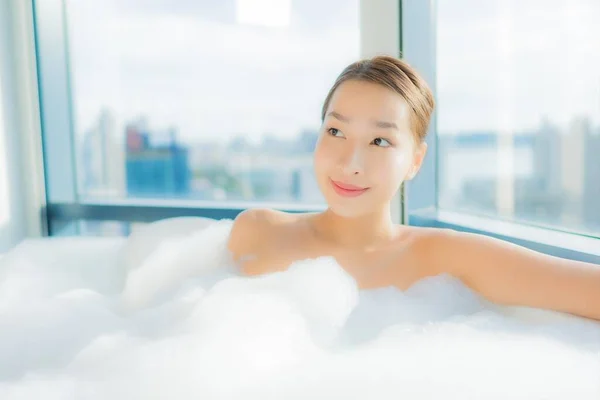 美しい若いアジアの女性の肖像画は バスルームのインテリアでバスタブでお楽しみください — ストック写真