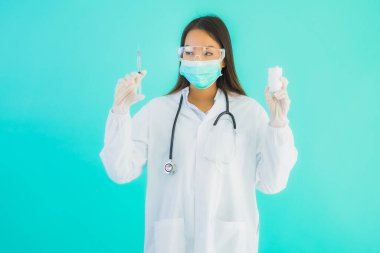 Aşı şırıngası ve kuraklığı olan güzel Asyalı doktor kadın portresi veya mavi arka planda hastane veya klinikte kullanılmak üzere ilaç şişesi.
