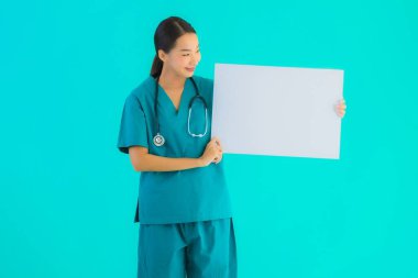 Fotokopi için boş kâğıt tahtası olan güzel Asyalı genç doktor kadın hastane ve klinikteki sağlık hizmetleri konseptinde mavi izole edilmiş arka plan.