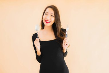 Kaşığı ve çatalı olan güzel Asyalı bir kadının portresi izole edilmiş renkli arka planda yemeye hazır.