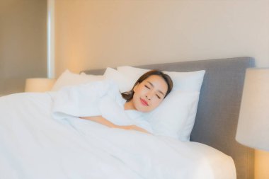 Asyalı güzel bir kadının portresi. Gülümse. Yatak odasında rahatla.