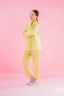 Portre güzel Asyalı genç iş kadını pembe arka planda gülümsüyor