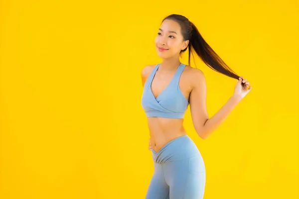 穿着运动鞋的年轻貌美的亚洲女运动员 准备在黄色孤立的背景下进行锻炼 — 图库照片