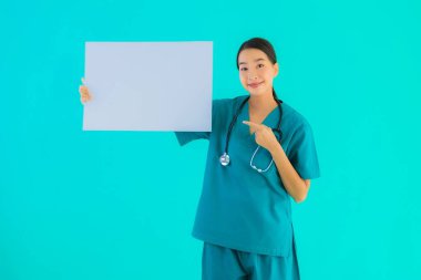 Fotokopi için boş kâğıt tahtası olan güzel Asyalı genç doktor kadın hastane ve klinikteki sağlık hizmetleri konseptinde mavi izole edilmiş arka plan.