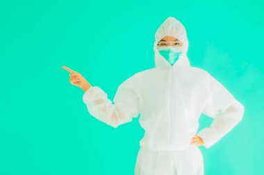 Güzel, genç Asyalı doktor kadın portre. Koronavirüsten ya da mavi arka planda kovid19 'dan korunmak için ppe ya da kişisel koruyucu ekipman takıyor.