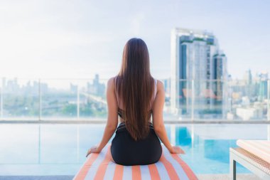 Güzel bir Asyalı kadının portresi tatil gezilerinde yüzme havuzunda rahatlar.