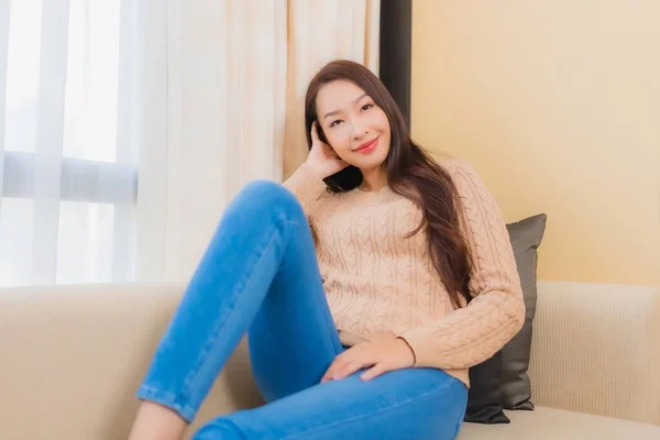 ポートレート美しい若いアジアの女性リラックス笑顔上のソファ装飾室内の幸せ — ストック写真