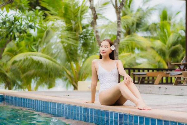 美丽动人的年轻亚洲女人在度假旅行时 在度假胜地酒店的室外游泳池边微笑着放松一下 — 图库照片