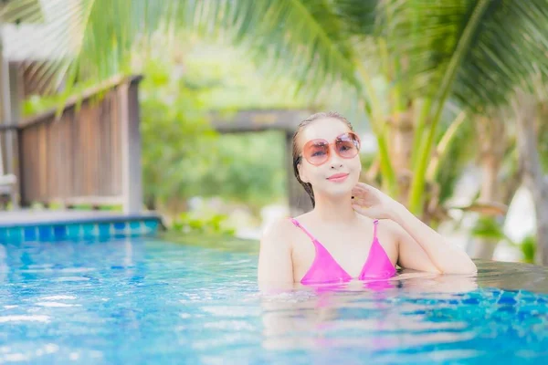ポートレート美しい若いアジアの女性の笑顔休暇旅行でリゾートホテルの屋外スイミングプールの周りにリラックス — ストック写真
