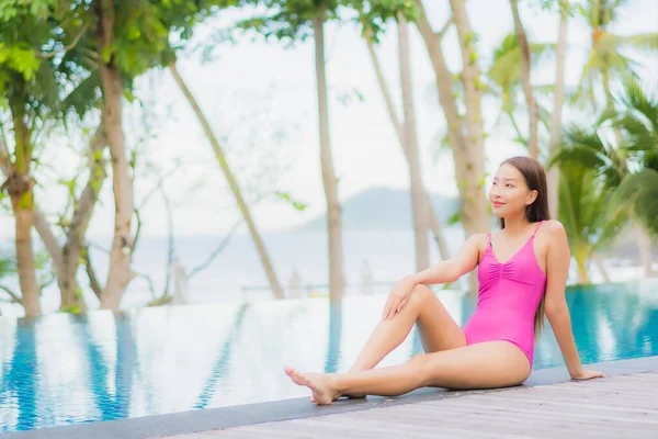 美丽动人的年轻亚洲女人在度假旅行时 在度假胜地酒店的室外游泳池边微笑着放松一下 — 图库照片