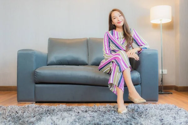 在客厅的沙发上 年轻美丽的亚洲女人在客厅里放松一下 — 图库照片