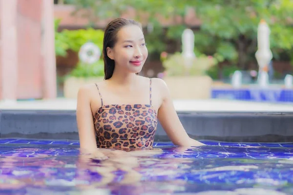 ポートレート美しい若いアジアの女性は休暇旅行で屋外スイミングプールの周りの笑顔のレジャーをリラックス — ストック写真