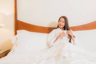Güzel bir Asyalı kadının portresi. Gülümse. Yatak odasında rahatla.
