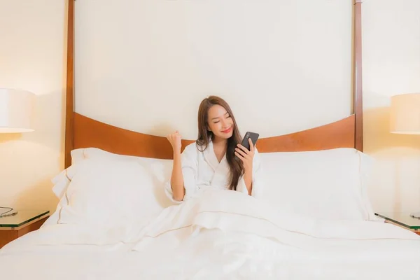 아름다운 침대에서 스마트폰을 사용하는 — 스톡 사진
