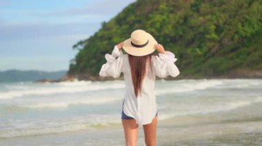 Güzel Asyalı kadının yaz tatilinde deniz kıyısında dinlendiği görüntüler.