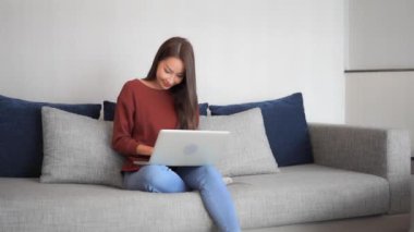 Evde dizüstü bilgisayarla çalışan Asyalı güzel bir kadının görüntüleri.