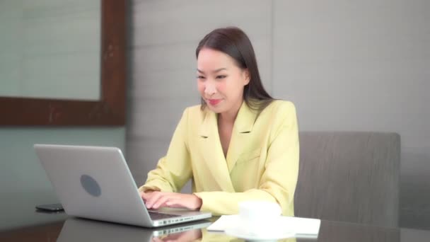 집에서 노트북을 가지고 일하는 아름다운 이시아 여성의 — 비디오