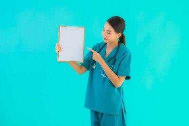 Fotokopi için boş kâğıt tahtası olan güzel Asyalı genç doktor kadın hastane ve klinikteki sağlık hizmetleri konseptinde mavi izole edilmiş arka plan.