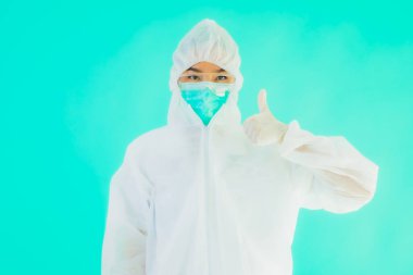 Güzel, genç Asyalı doktor kadın portre. Koronavirüsten ya da mavi arka planda kovid19 'dan korunmak için ppe ya da kişisel koruyucu ekipman takıyor.