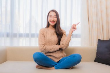 Güzel bir Asyalı kadın portresi rahatla. Gülümse. Yatak odasının iç dekorasyonunda mutlu ol.