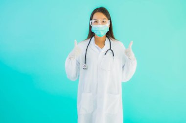 Klinikte ya da hastanede maske takmış güzel Asyalı genç doktor kadın portresi.