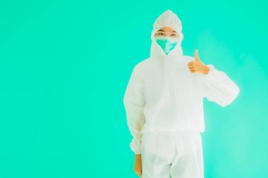 Güzel, genç Asyalı doktor kadın portre. Koronavirüsten ya da mavi arka planda kovid19 'dan korunmak için ppe ya da kişisel koruyucu ekipman takıyor.