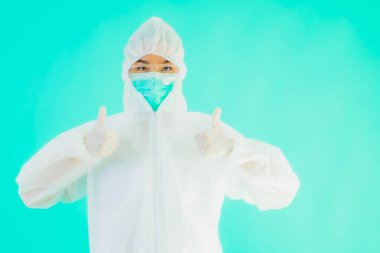 Güzel, genç Asyalı doktor kadın portre. Koronavirüsten ya da mavi arka planda kovid19 'dan korunmak için ppe ya da kişisel koruyucu ekipman takıyor.