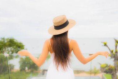 Portriat güzel genç Asyalı kadın deniz manzaralı balkonda mutlu bir gülümseme