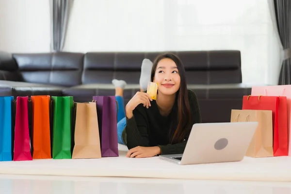 亚洲年轻貌美的女人 带着购物袋和信用卡 带着手机在家网上购物 — 图库照片