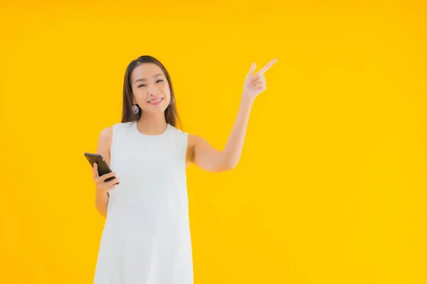 Porträtt Vacker Ung Asiatisk Kvinna Med Smart Mobiltelefon Gul Isolerad — Stockfoto