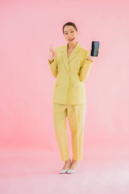 Güzel Asyalı iş kadını portresi. Arka planda kahve fincanı ve akıllı cep telefonu kullanıyor.