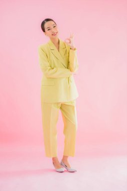 Portre güzel Asyalı genç iş kadını pembe arka planda gülümsüyor