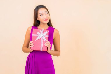 Güzel bir Asyalı kadın portresi. Kırmızı hediye kutusu ve izole edilmiş bir arka plan.