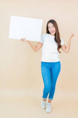 Güzel bir Asyalı kadın portresi. Krem arka planda boş beyaz ilan panosu kağıdı gösteriyor.