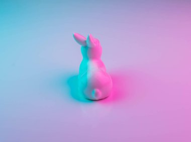 Renkli ultraviyole holografik neon ışıkları ile beyaz Paskalya tavşanı. Yaratıcı kavramı.