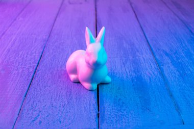 Mavi ahşap arka plan üzerinde beyaz Paskalya tavşanı