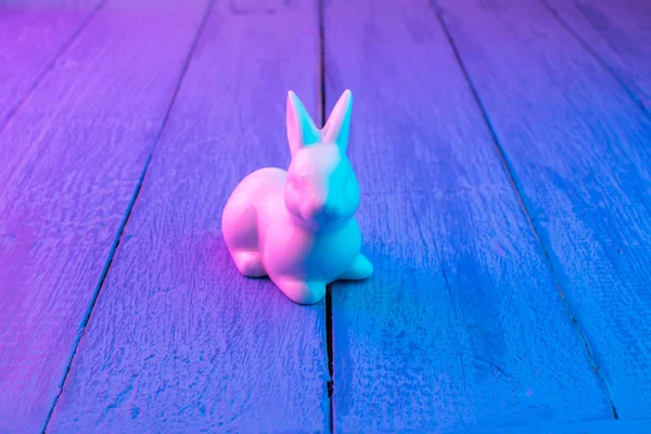 Mavi ahşap arka plan üzerinde beyaz Paskalya tavşanı