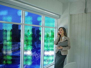 Modern iş kadınları iş concep pencereden dışarı bakarak beyaz borsa hakkında mobilephone konuşmak kullanın