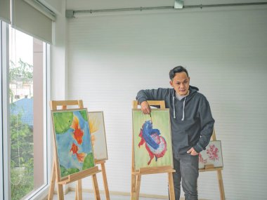 Studio boya kullanmayı öğretmek yakışıklı genç Asyalı adam veya su renk sanatçı