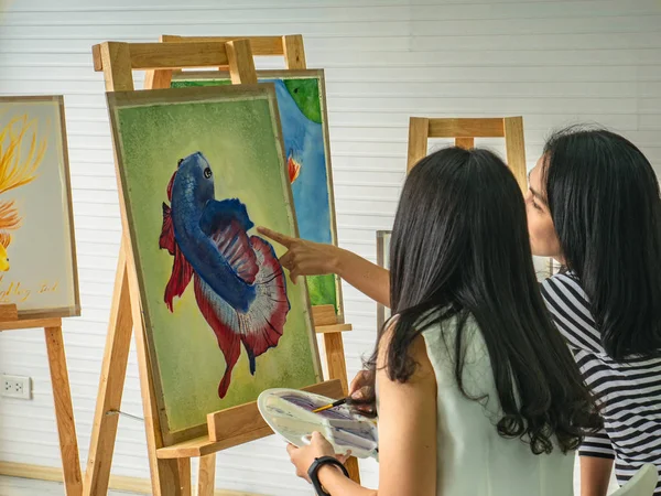 İki genç Asyalı kadın sanatçı, birlikte en iyi sanat eserini yaratmak ve düşünmek için fikirler üreterek şafak sökerken, balık kavramı.