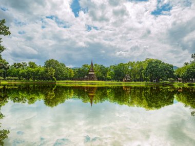 Sukhothai tarihi parkındaki Pagoda harabesi ve heykel yansıması Tayland 'da.