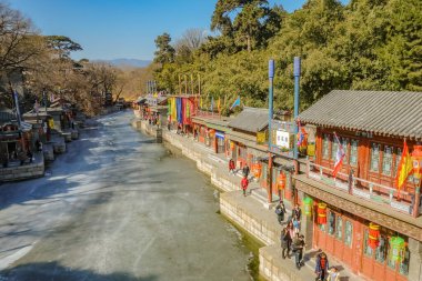 Pekin / Çin - 26 Şubat 2017: Çin 'in başkenti Pekin' deki Yaz Sarayı 'nda buzul nehrinin kenarında yürüyen yabancı Çinli veya turist